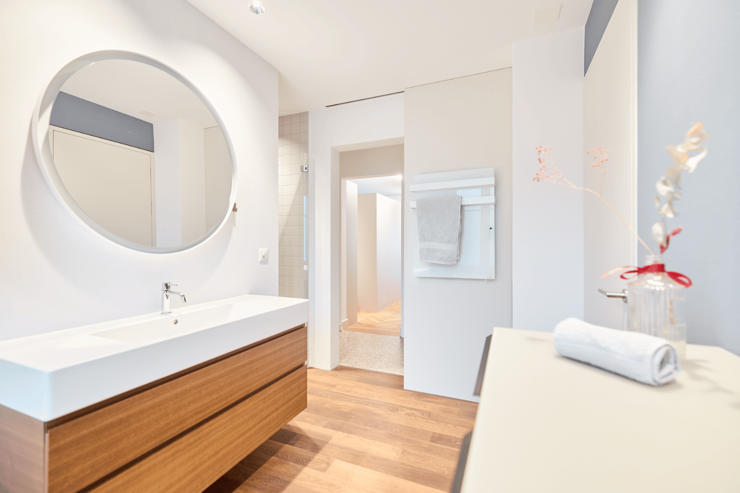 ecoQ Bagno 700+ Badezimmerheizung in Weiss mit Handtuchalter, auf dem flauschige Handtücher hängen.