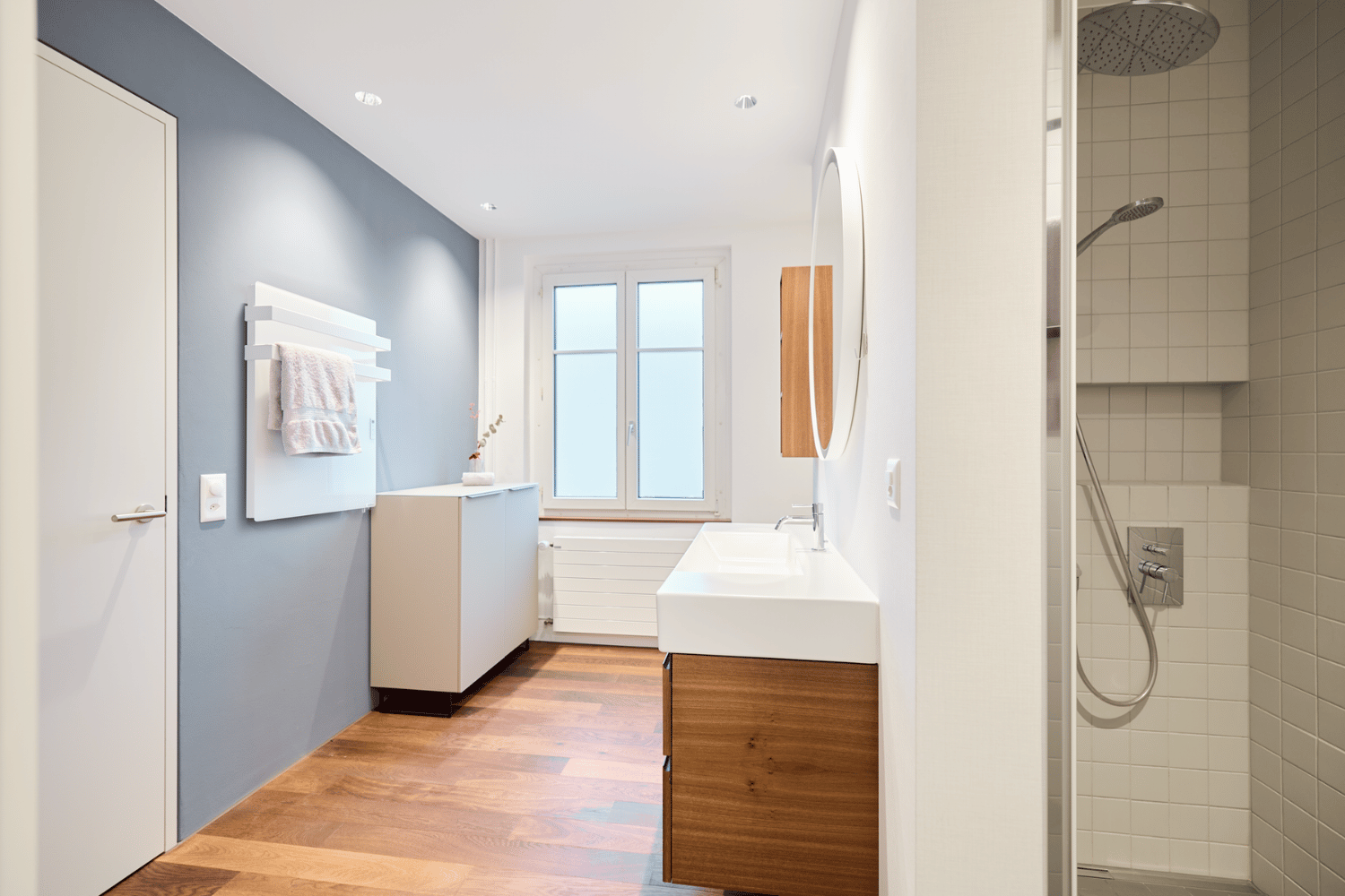 Elegante ecoQ Bagno 700+ Badezimmerheizung mit Handtuchalter in Weiss, dezent in ein modernes Badezimmer integriert.