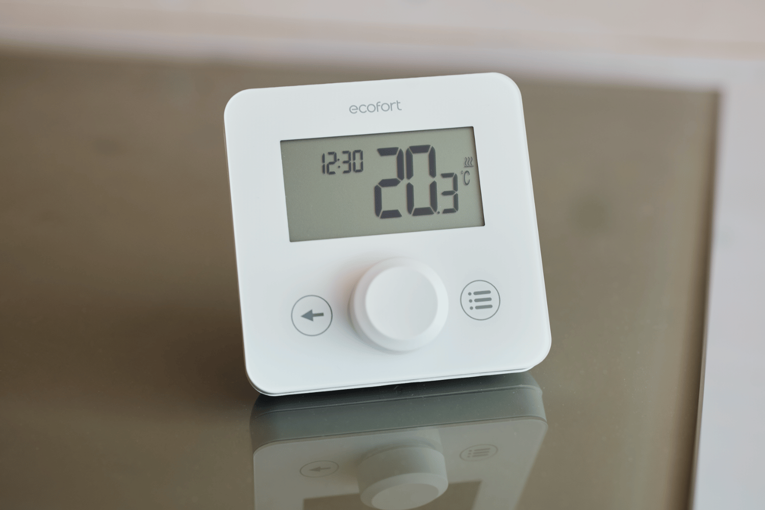 Modernes Thermostat mit digitaler Anzeige und Touch-Bedienung an einer Wand.
