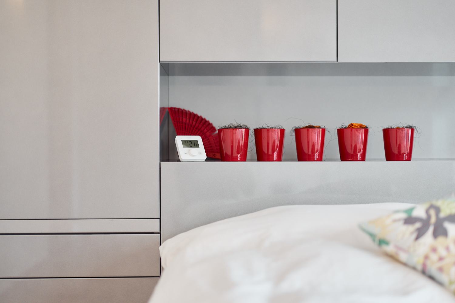 ecoheat Sensus Thermostat auf einem Regal hinter einem Bett